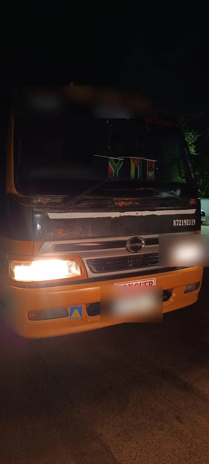 One of the intercepted vehicles at Beira, photographed at night; plate, fleet number and operator name are blurred