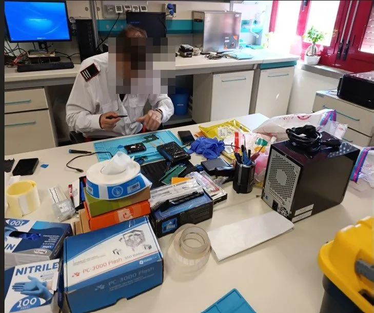 Digital and electronic forensic training: an officer at the workbench; the face is pixelated