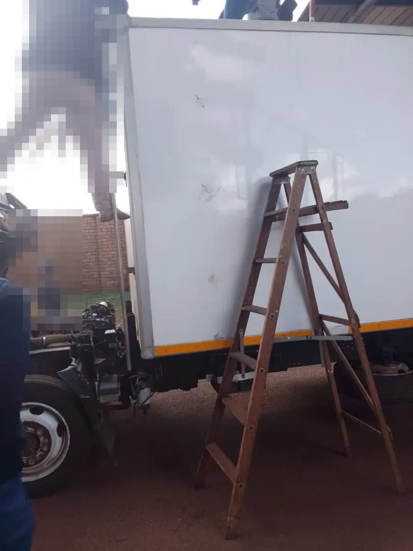 Opening the cargo body of the truck at Lomahasha; persons pixelated