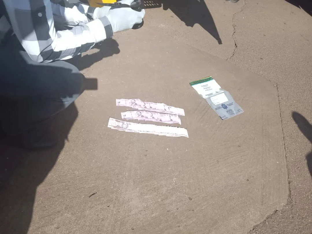 Strips of banknotes recovered from the vehicle, laid on the tarmac