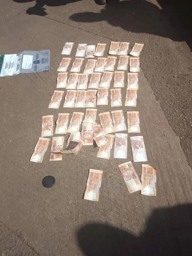 Rand notes laid out in rows for counting beside the truck