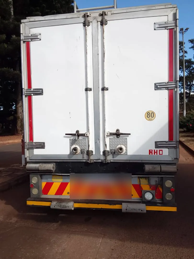 The rear doors of the truck; the registration plate is blurred