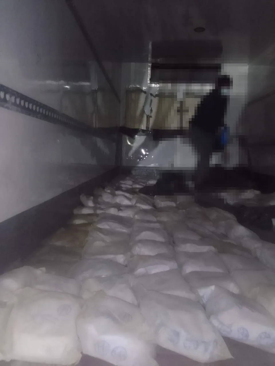 Inside the intercepted truck at Badplaas: packages laid across the load bed; the person present is pixelated