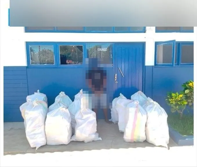 Bags of seized methamphetamine outside a police building in Vilankulo; signage blurred, person pixelated