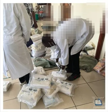 Forensic staff examining the Vilankulo packages; faces pixelated